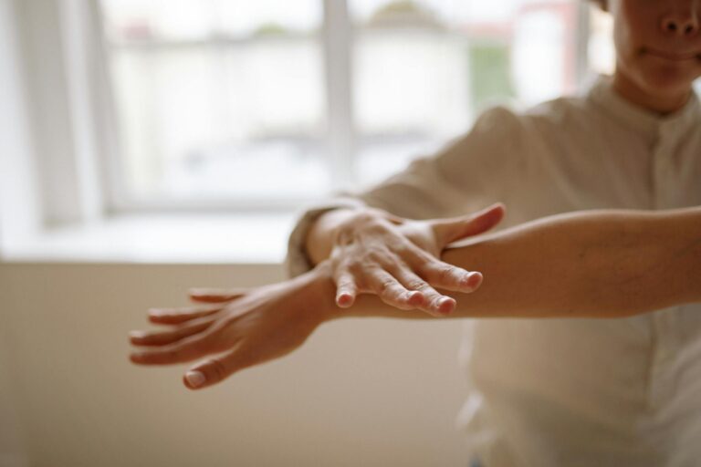 A close-up view of a person using a relaxation technique with hands in motion, in a bright, airy space.