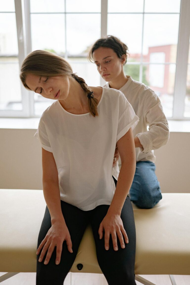 A massage therapist provides a relaxing session in a sunlit studio, creating a peaceful atmosphere.