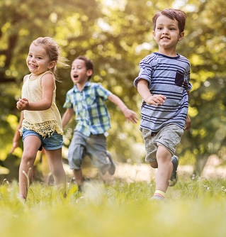 group of happy kids having fun while running in the park.